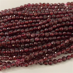 Flade runde Rød grantat perler. De måler ca. 4 x 2,5 mm Der er ca. 100 perler på strengen der er 40 cm. lang.