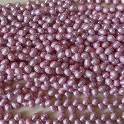  baby lyserøde ferskvandsperler - Strengen måler ca. 37 cm. lang og der er ca. 75 perler på.